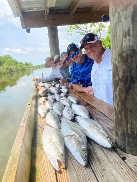 Anglers lined up along the cleaning dock behind their catch in Venice, Louisiana