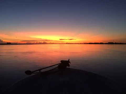 First light over the delta seen past the trolling motor on the bow