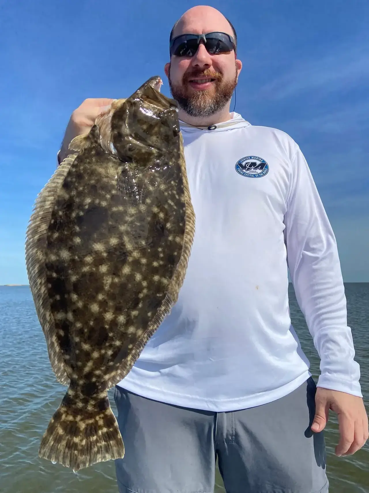 Angler holding a large flounder on the boat near Venice, Louisiana
