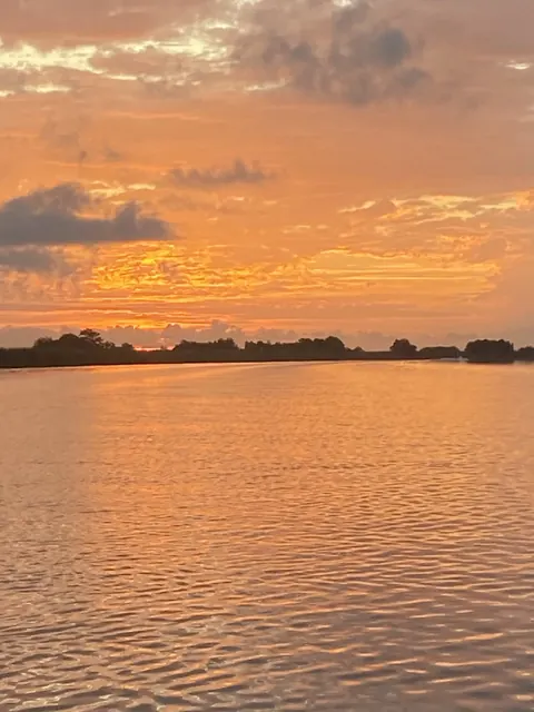 Orange clouds reflected in the water near Venice, Louisiana