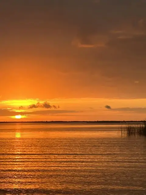 Orange sky and low sun over the water near Venice, Louisiana