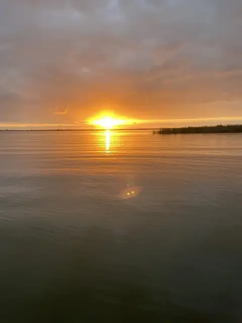 Sun low over calm water in the Venice, Louisiana delta